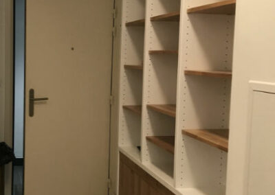 Bibliothèque en médium peint et chêne massif dans un espace exigüe avec des portes en bas