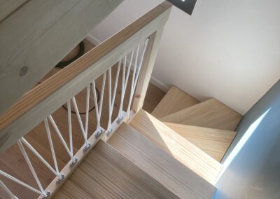 Vue du haut de l'escalier avec main courante bois et cordage
