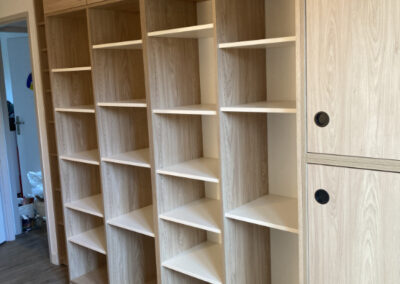 Meubles étagères et meubles portes coulissantes en stratifié décor chêne texturé en 7 modules pour un dressing