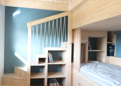 Filet d'habitation tendu entre un mur et un lit superposé style cabane