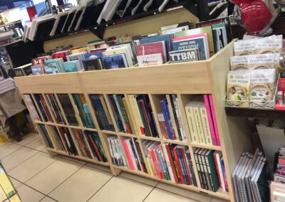 Meuble avec casiers pour des BD dans une librairie en pin radiata verni et légèrement blanchi