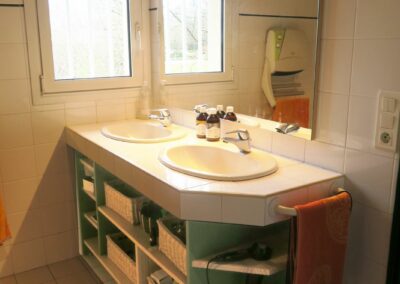 Meuble sous lavabos dans salle de bain en medium hydrofuge peint et tablettes en pin radiata vernies