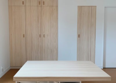 Des placards en mélaminé avec des portes en pin et un espace de rangements transformé en bureau pour les enfants